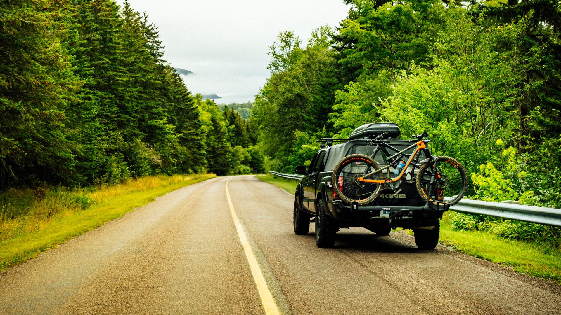 Toyota Tacoma equipped with mountain bikes driving through Fundy National Park.